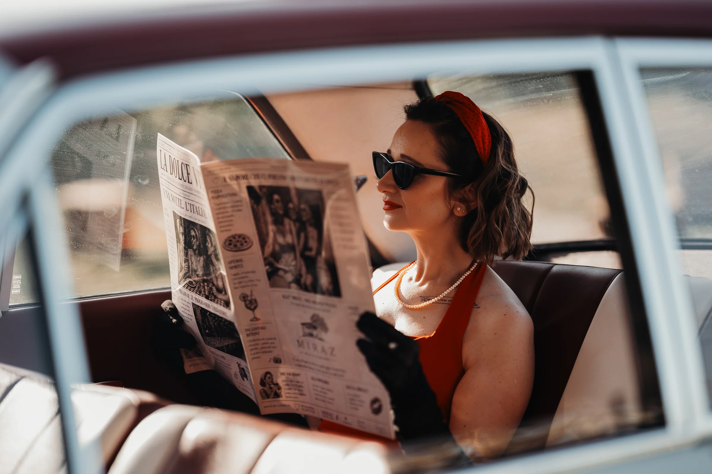 Retro portret žene u automobilu s novinama